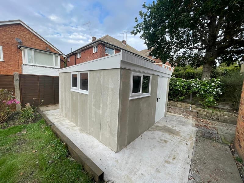 Concrete garden shed with windows installed on a concrete base in a UK garden