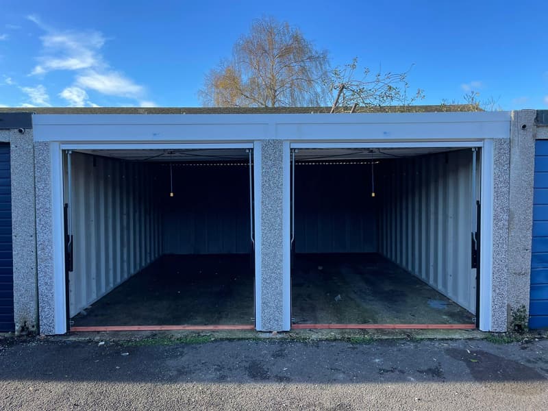 Bank of battery concrete garages with doors open showing interior space