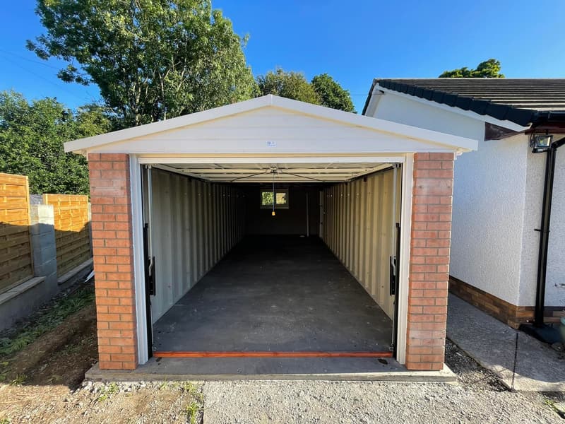Elite concrete garage with brick front columns and white up-and-over door