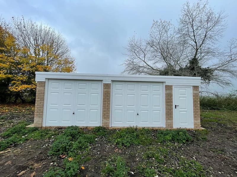Double concrete garage with side personnel door installed on a rural plot