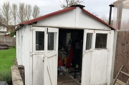 Old dilapidated garage with a rusting roof, ready for removal by Nucrete